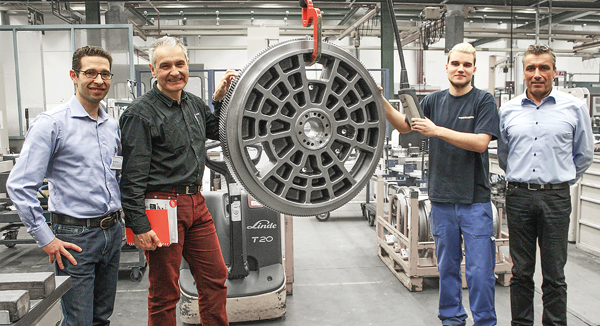 Mitarbeiter der Heidelberger Druckmaschinen AG und ARNO Werkzeuge mit einem Zahnrad
